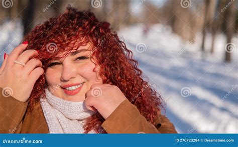 Portrait Of A Smiling Chubby Red Haired Woman On A Walk In Winter