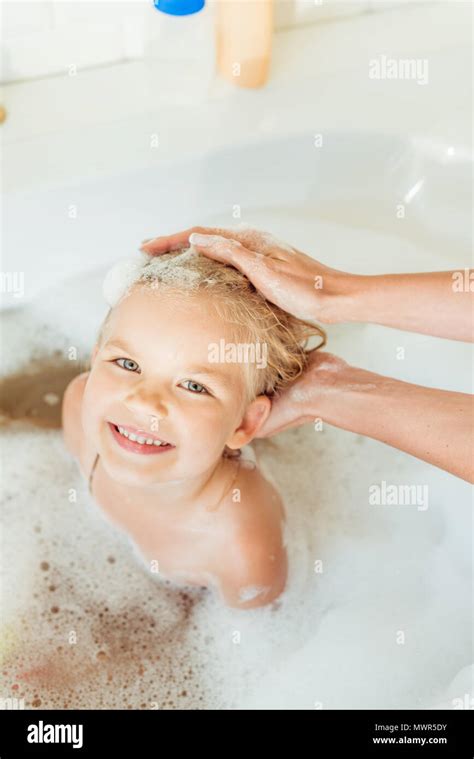 Cropped Shot Of Mother Washing Adorable Little Daughter In Bathtub