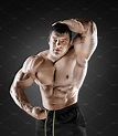 Handsome muscular bodybuilder posing over black background. | High ...