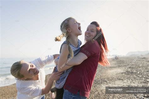 Lesbian Couple And Babe Laughing On Sunny Beach Caucasian Women Stock Photo
