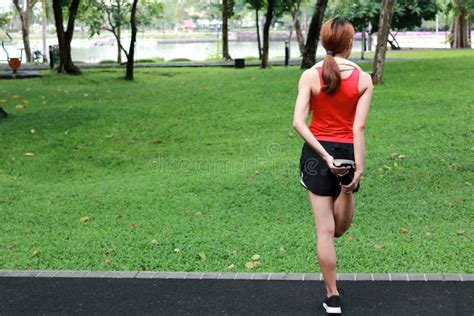 Healthy Asian Woman Stretching Her Legs Before Run In Park Fitness And Exercise Concept Stock