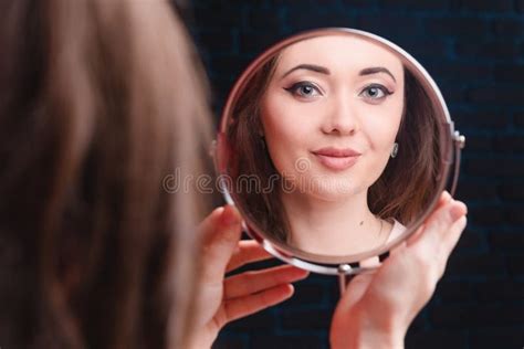 Beautiful Woman Chooses A Cosmetic Product Studio Photo On A Red