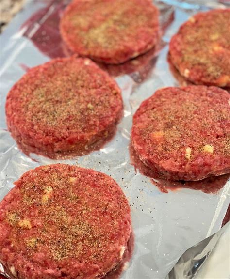 Some Hamburger Patties Are Sitting On Top Of Tin Foil And Ready To Go