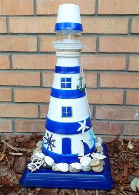 A Blue And White Lighthouse Made Out Of Seashells Sits On The Ground In