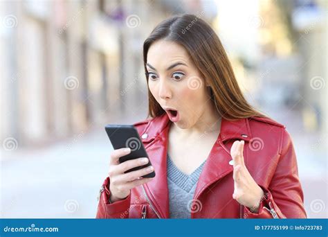 Surprised Woman With Mouth Open Looking At Her Phone Stock Image