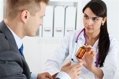 Beautiful Female Medicine Doctor Giving Pills To Male Patient Stock