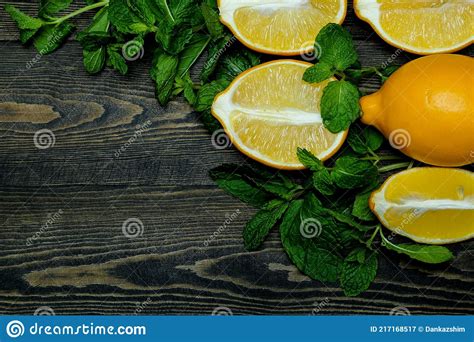 Whole Bright Yellow Lemons And Halves Of Lemons With Mint Leaves Laid