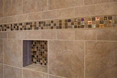 Say farewell to tiny mosaic tiles in 2021—at least when it comes to bathroom walls. Master bathroom shower, closeup on accent tile ...