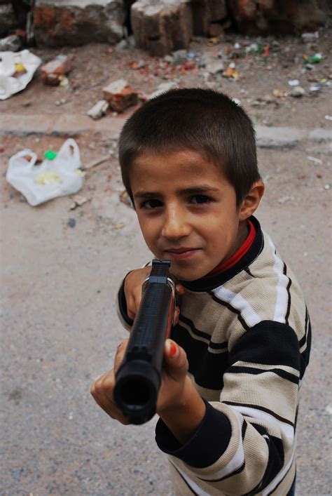 Boy Holding Pistol Toy Gun Pointing Smiling Trash Child Kid