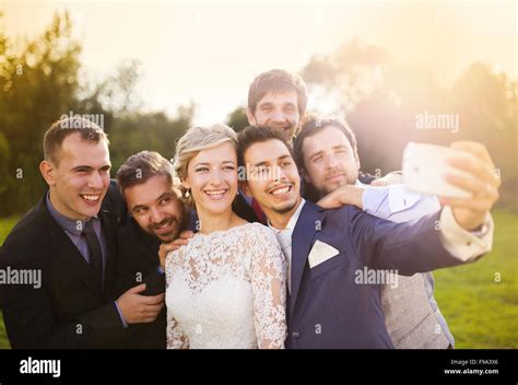 Outdoor Portrait Of Beautiful Young Bride With Groom And His Friends