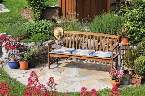 A Cushioned Wooden Garden Bench Resting On An Outside Patio With
