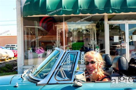 57 Year Old Woman With Long Hair Driving Her Mg Convertible Car Flipping Off The Photographer