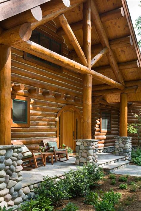 The Front Porch Of A Log Cabin With Stone Steps