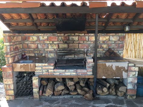 An Outdoor Grill With Wood Stacked On It