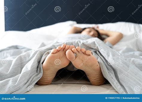 Feet Of Man Sleeping In Comfortable Bed Stretch After Wake Up In The Morning Man Relaxing