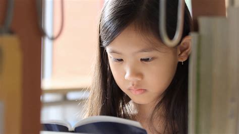 Little Asian Girl Reading A Book In Library Stock Video Footage 0021
