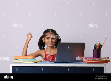 Little Girl Studying Online Using Her Laptop Or Computer At Home Stock