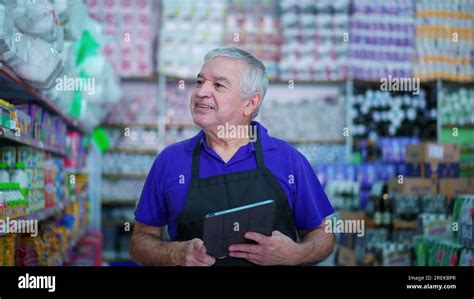 Joyful Senior Grocery Store Manager Checking Product Inventory on Shelf