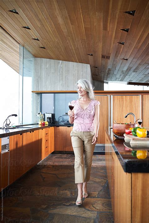 Mature Woman With Grey Hair Walking In Luxury Kitchen By Trinette Reed