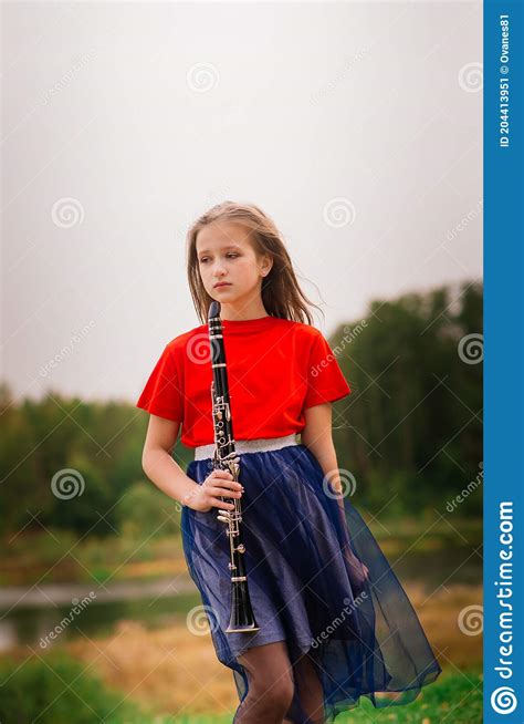 Young Attractive Girl Playing Clarinet Ebony In Fall Park Stock Image