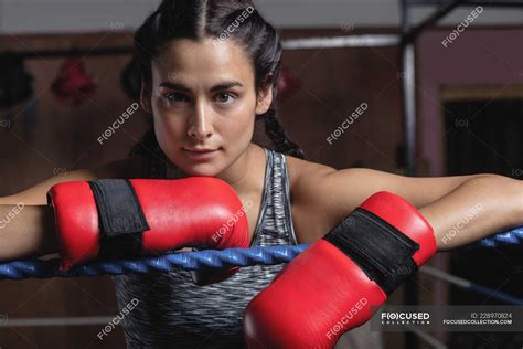 Portrait Of Tired Boxer In Boxing Gloves Leaning On Ropes Of Boxing