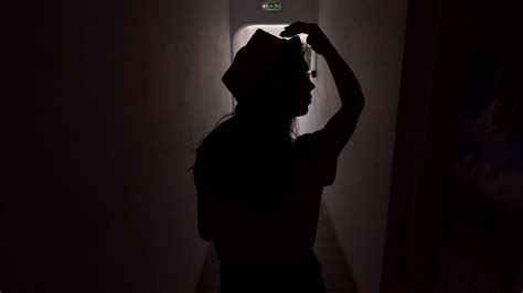 Choose from a wide range of similar scenes. Summer woman silhouette walking in dark corridor. Back view of walking woman in hat in hotel ...