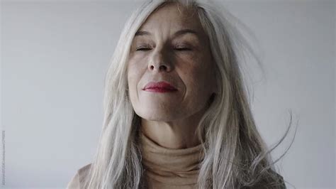 Portrait Of A Smiling Senior Woman With Grey Long Hair By Stocksy Contributor Bonninstudio