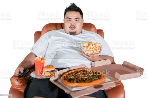 Overweight Man Eating Junk Foods On The Sofa Stock Photo Download