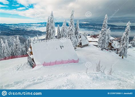 Snow Covered Wooden Lodges And Ski Slopes Poiana Brasov Romania Stock