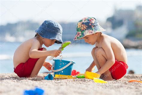 Dos Niños Lindos Jugando En La Arena En La Playa 2023