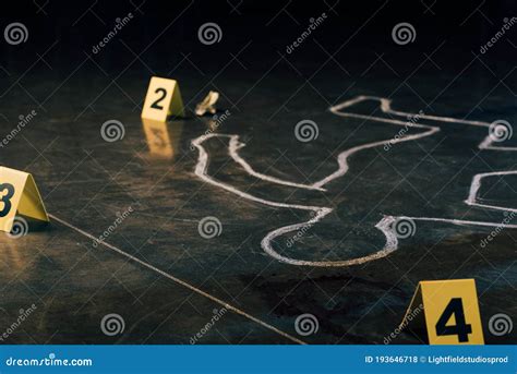 Focus Of Chalk Outline And Evidence Markers At Crime Scene Stock Photo