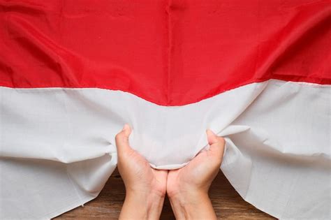 Mano Sosteniendo Y Tocando La Bandera Nacional De Indonesia Roja Y