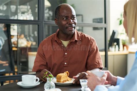 Mature African American Man Having Dessert During Conversation With His