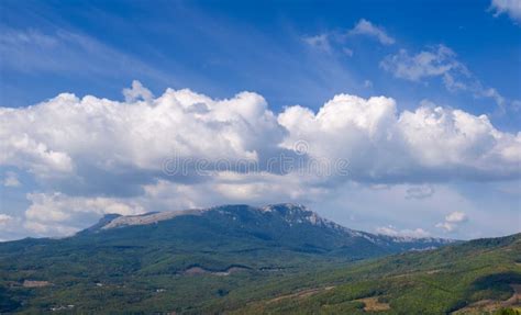Sky With Clouds Over Mountain With Slopes Covered With Forests Stock