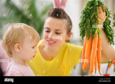 Mother Showing Baby Bunch Of Carrots Stock Photo Alamy