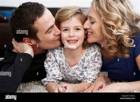 Parents Kissing Daughter On Cheeks Stock Photo Alamy
