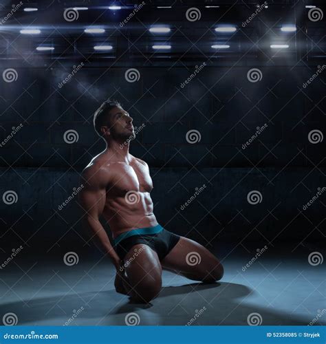 Thoughtful Athletic Man Kneeling On The Floor Stock Photo Image