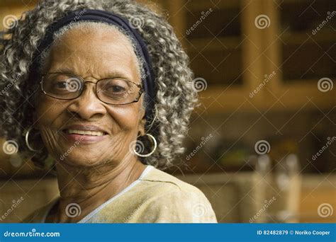 African American Grandmother And Granddaughter Relaxing In Park Stock