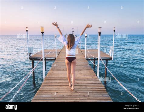 Happy Young Woman In Bikini With Raised Up Arms Walking On Pier Stock