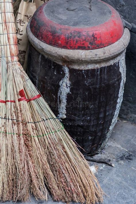 Vertical Shot Of A Traditional Chinese Broom And A Pot In An Old Alley