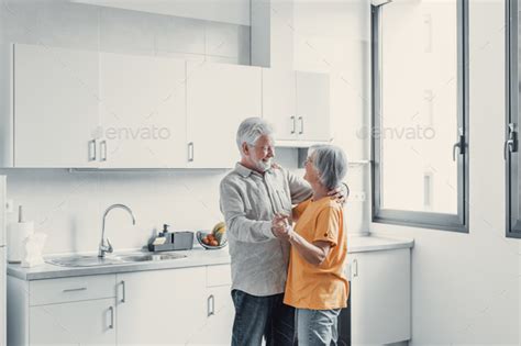 Joyful Active Old Retired Romantic Couple Dancing Laughing In Living Room Happy Middle Aged