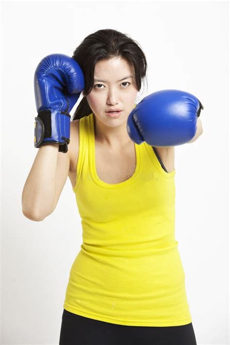 Portrait Of Young Asian Woman Wearing Boxing Gloves Against White