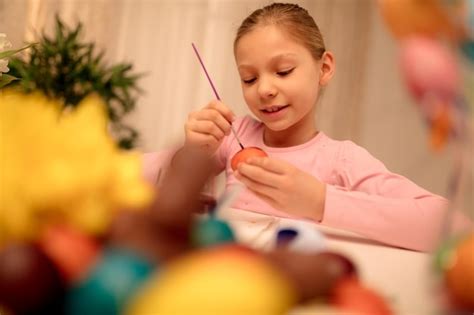 Premium Photo Cute Smiling Little Girl Painting Easter Egg At Home