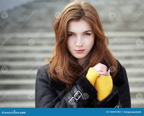 Fabulous Redhead Woman With Long Hair In Yellow Sweater Black Leather Jacket On Blurred Concrete
