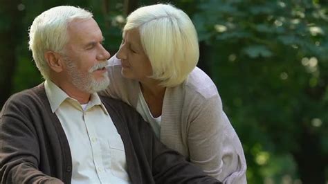 Old Wrinkled Man And Woman Kissing With Tenderness In Park Happiness