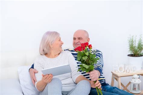 senior man surprising wife with a rose relationship getting old together love concept stock