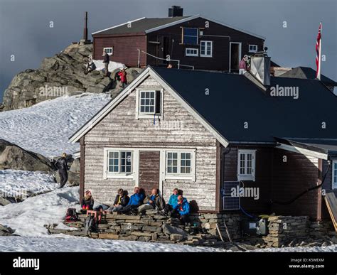 Mountain Hut On Top Of Mountain Fannaråken Hikers Sit Outside The Hut