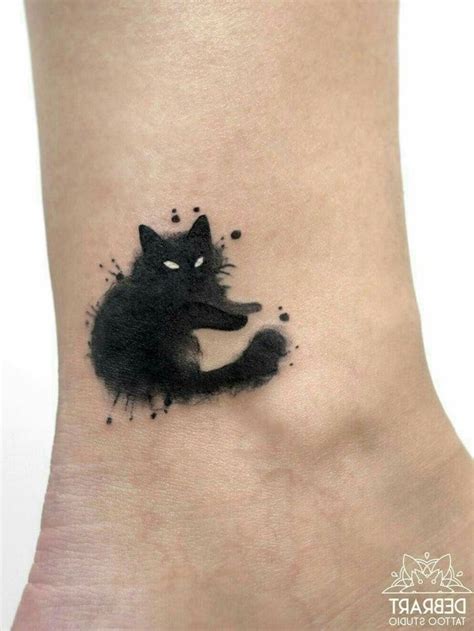 A Black Cat Tattoo On The Ankle With Watercolor Paint Splatters All Over It