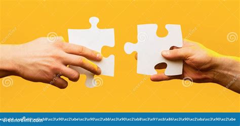 Two Hands Trying To Connect Couple Puzzle Piece On Yellow Background