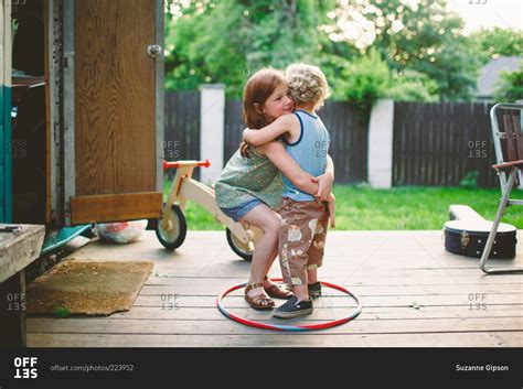 Girl Bending Down To Pick Up Little Boy Stock Photo Offset